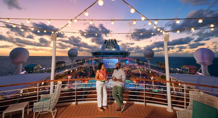 Couple relaxing on top deck of the Freedom of the Seas at dusk