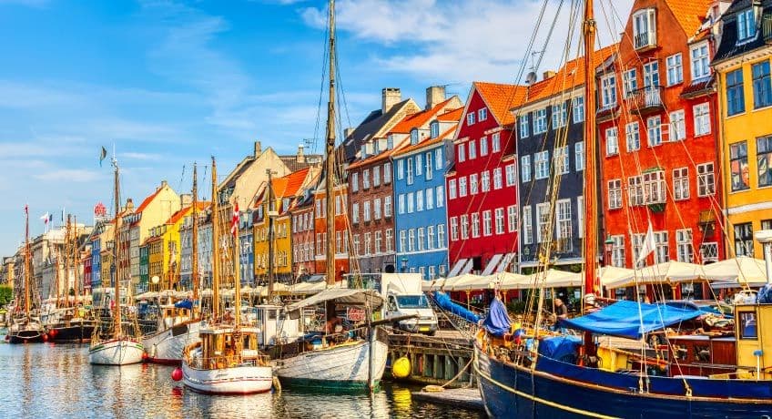 Boats & colourful buildings line the shore in Copenhagen