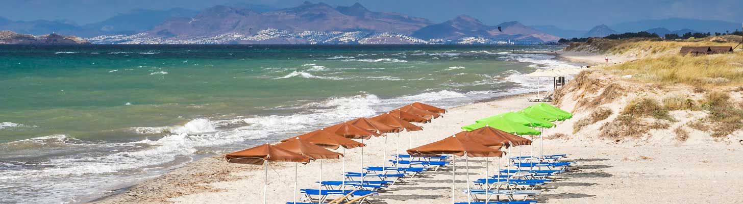 Sun umbrellas line the beach at Mastichari in Kos