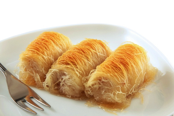 Shredded pastry soaked in syrup, Kataifi is a Greek dessert.