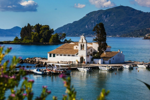The greek island of Corfu and its breathtaking green backdrop, accompanied by a whitewashed monastery perched on the water.