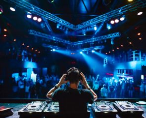 DJ playing music in a club while party-goers dance the night away