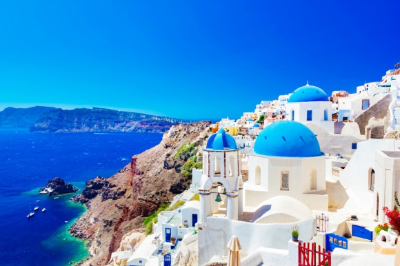 The blue-domed whitewashed town of Oia town on Santorini island, Greece. Caldera on Aegean sea.