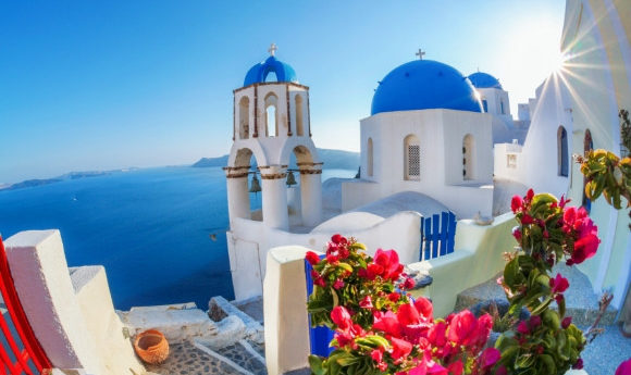 Whitewashed village in Santorini and close up of blue-domed houses in Santorini