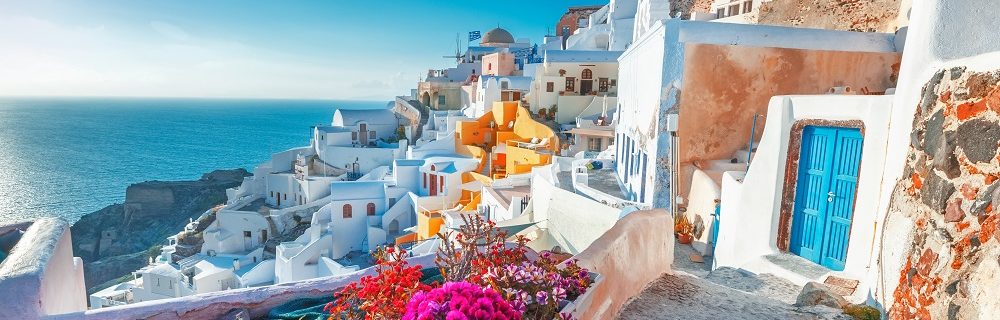 Mesmerising views of Fira and its whitewashed blue-domed houses and floral landscapes in Santorini, Greece.