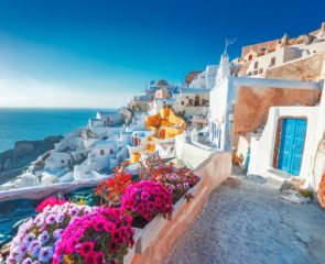 Mesmerising views of Fira and its whitewashed blue-domed houses and floral landscapes in Santorini, Greece.