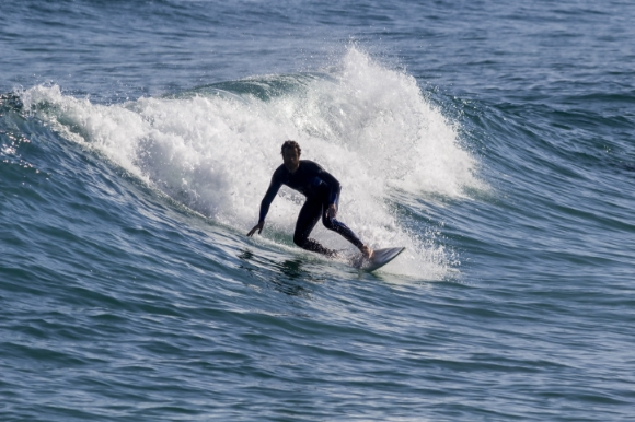 Man surfing in the Atlantic Ocean on Tavira Island Beach in Portugal's Algarve