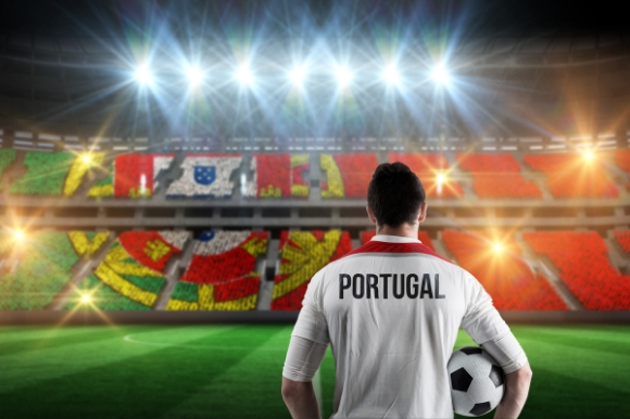 Portuguese footballer standing in a stadium holding a ball