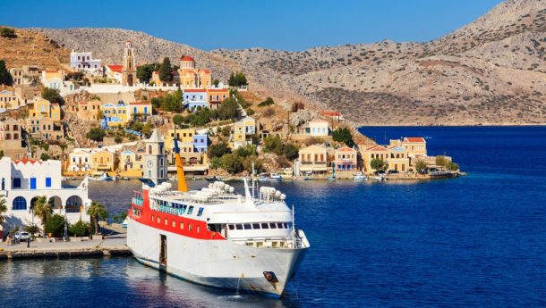 Overlooking the Harbour at Symi Greece with a ferry in Port. Greece Europe.