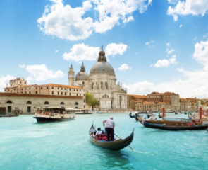 The beautiful Grand Canal in Venice surrounded by Basilica Santa Maria della Salute with a travelling gondola