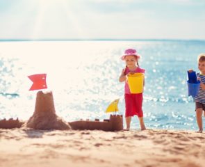 Little boy and girl sandcastle building on the beach