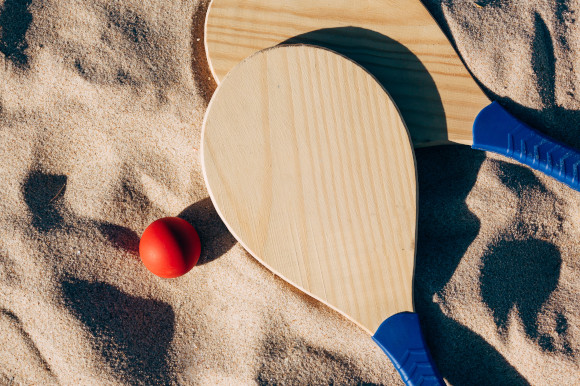 Wooden bat and ball placed on the sand