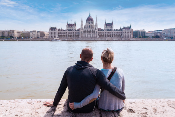 Couple admiring the Hungarian Parliament Buildings from the water's edge
