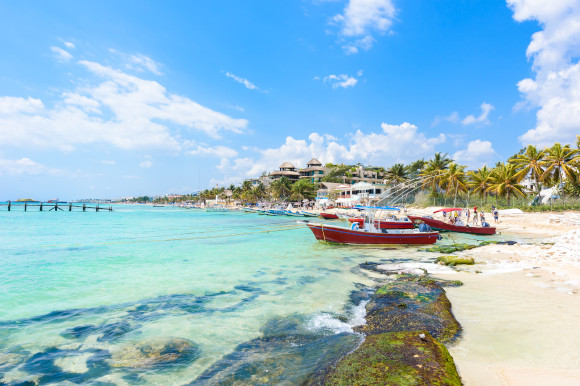 Playa del Carmen - relaxing on chair at paradise beach and city at caribbean coast of Quintana Roo, Mexico