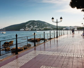 Santa Eulalia's beautiful promenade surrounded by the Mediterranean Sea with a beautiful green hill sitting in the distance