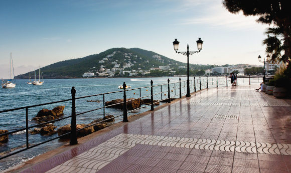 Santa Eulalia's beautiful promenade surrounded by the Mediterranean Sea with a beautiful green hill sitting in the distance