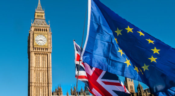 European and UK flag in front of Big Ben with a bright blue sky as the backdrop