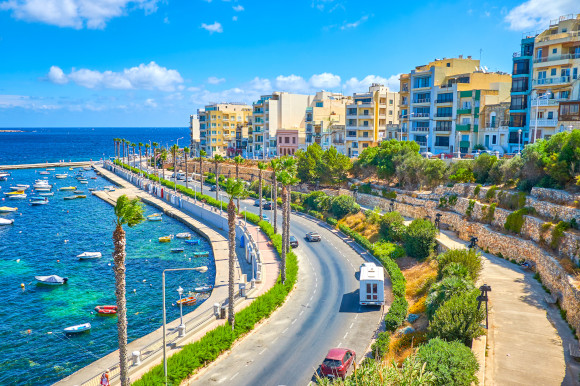The coastal road of Bugibba resort on a sunny day in Malta