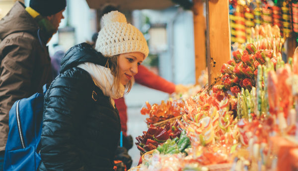 A woman shopping for gifts at a Christmas market
