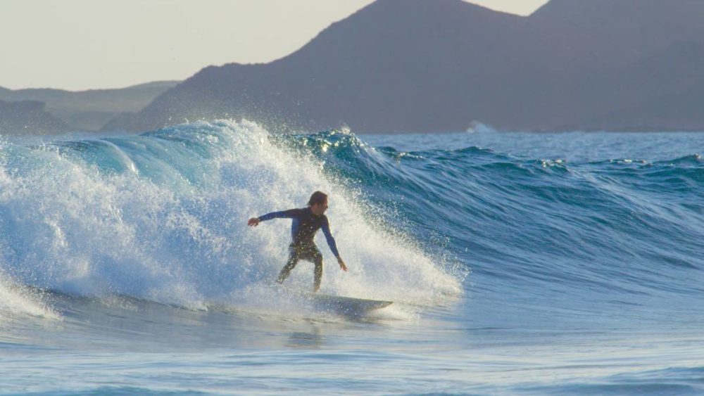 A surfer riding the big waves on a beach in Fuerteventura