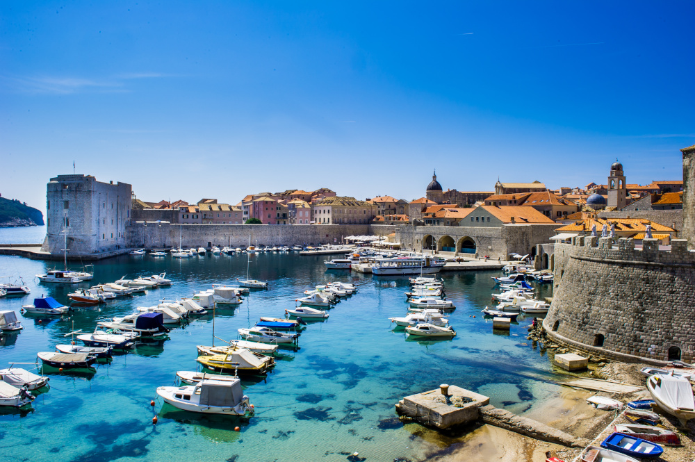 Port of Dubrovnik with a scattering of boats and the city walls in the backdrop