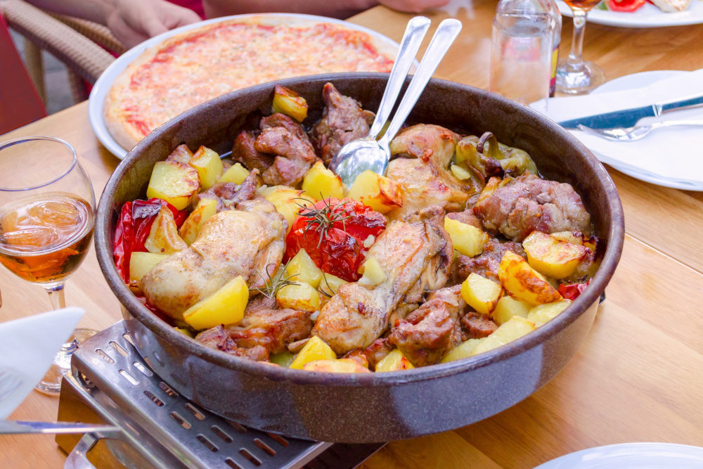 traditional croatian food peka with mix meat, vegetables and wine