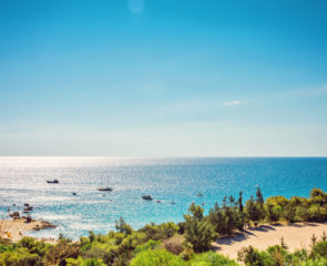 A far-stretching view of Konnos Beach in Protarus dotted with greenery