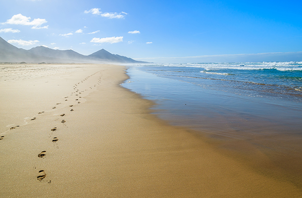 View of beach on Canary Islands with footprints in the sand