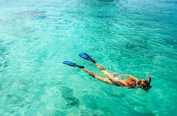 Woman snorkelling in aquamarine waters