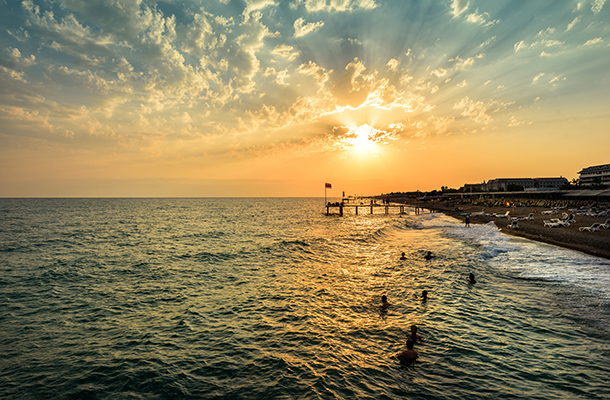 People swimming in the sea in Kusadasi Turkey at sunset