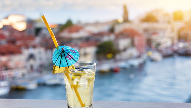 Cocktail with blurred Croatian town in background